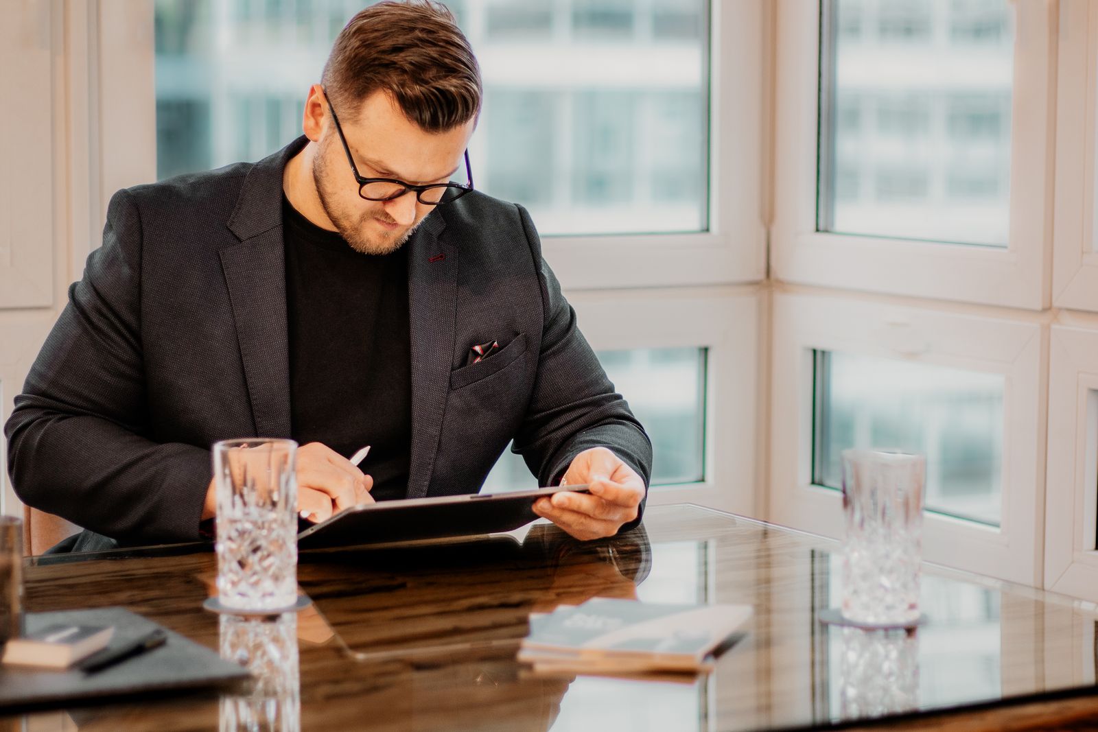 Benjamin Fitzner arbeitet am Besprechungstisch mit einem Tablet