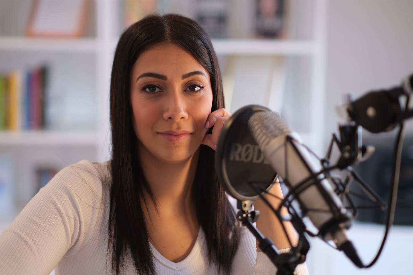 Ipek Fitzner lächelt in die Kamera, vor ihr ein Mikrofon